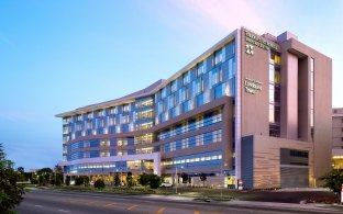 Outdoor image of the medical center with blue windows and a blue sky