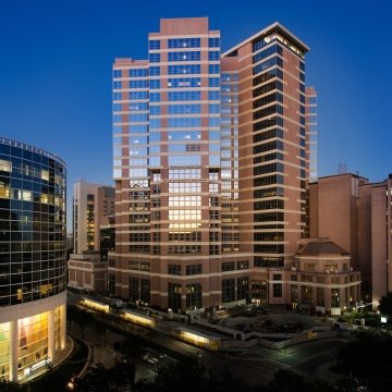 Exterior view of the tall hospital tower surrounded by other buildings.