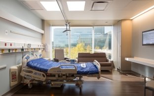 A patient room with hospital bed and couch