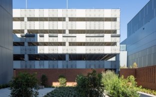 Exterior view of the VA hospital building with a courtyard in the forefront of the image