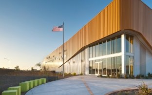 Outdoor image of the enterance with a flag pole and green seats