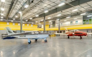 Indoor hanger with two planes one red and one sky blue